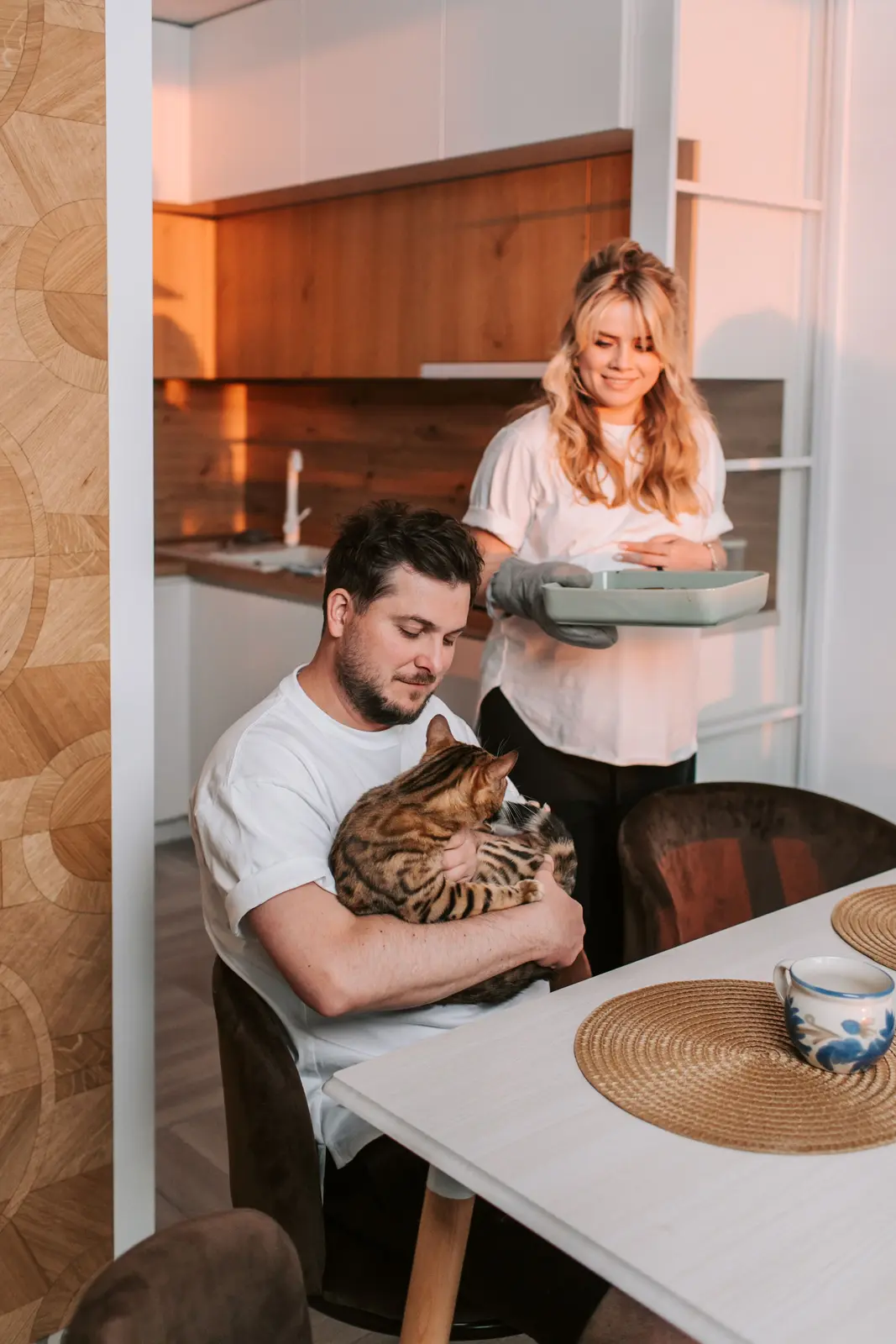 A couple spending time at home with their Bengal cat